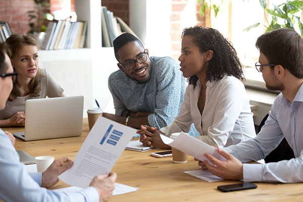 Three males and two females at conference table