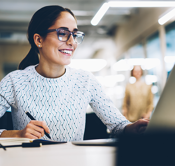 Smiling business woman with glasses looking at computer