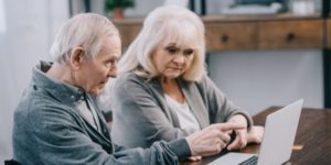 Elderly man and woman looking at computer