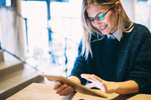 Woman reading on a tablet and smiling