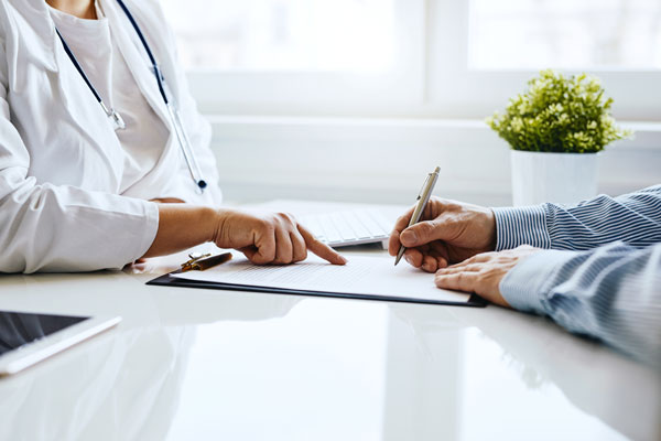 doctor pointing to a paper with patient writing on it