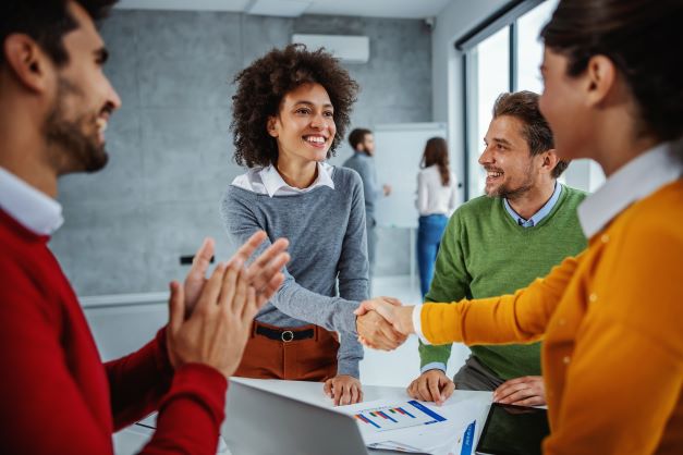 Woman accepting congratulations from coworkers