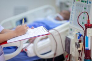 nurse writing on clipboard medical bed in background