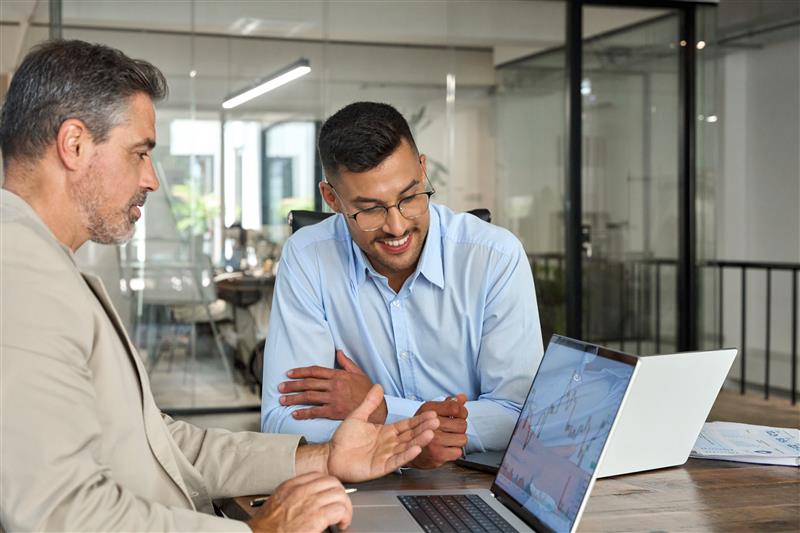 Two men looking at data on a laptop